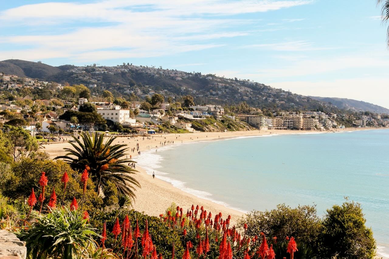 Coastline of Pacific Ocean in Laguna Beach. Mountains are in the distance of a beach.
