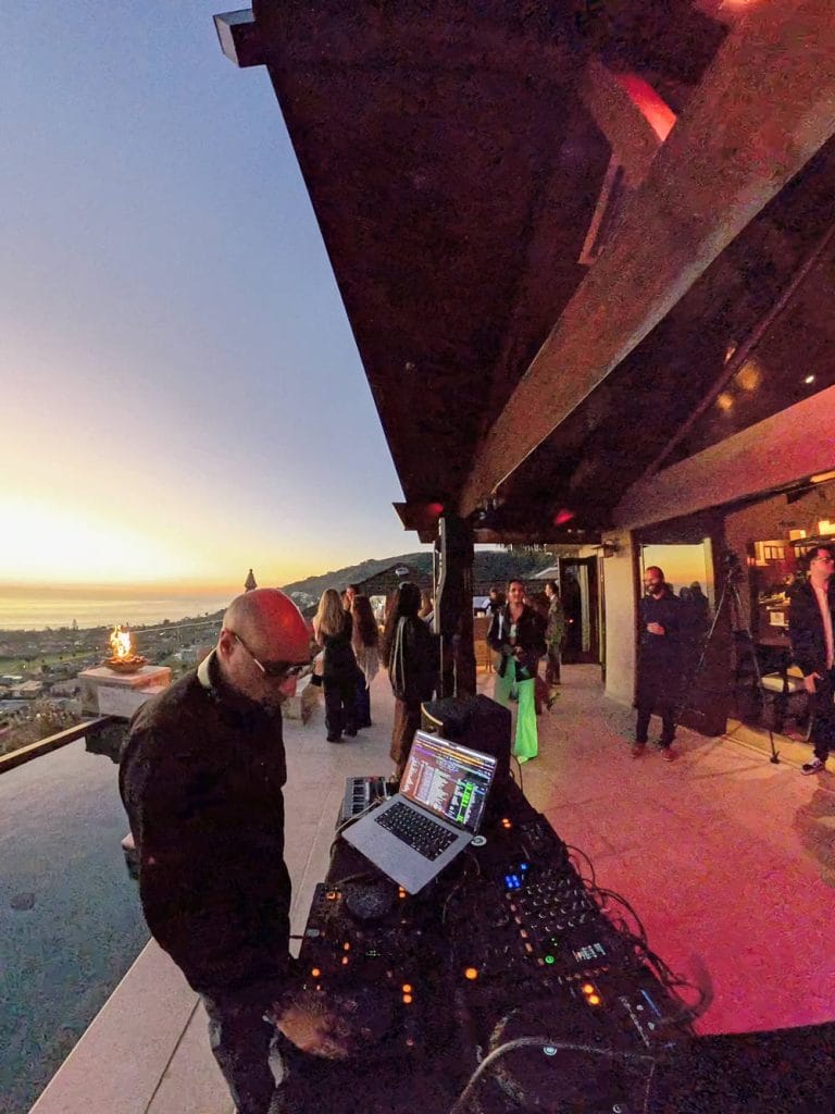 DJ at a house overlooking a sunset on the ocean