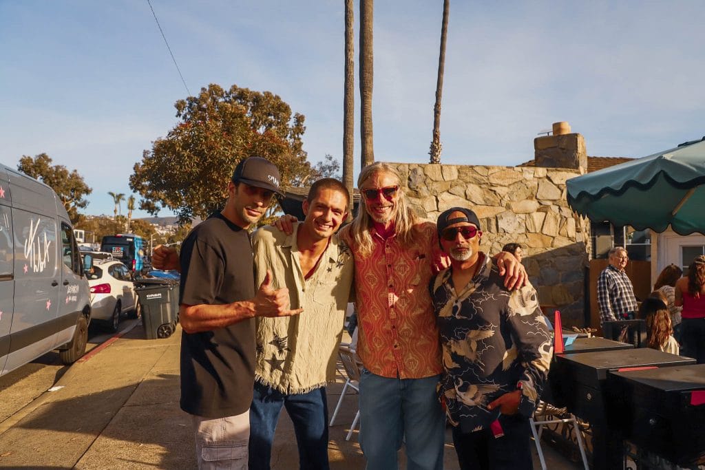 four men pose at a coffee shop party